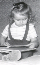 Author Sybil Johnson as child, age 2, looking at books